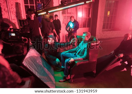 MOSCOW - OCT 23: Director, staff and actors on the set of the video singer Rene during scene with a man on a chair in White studio on October 23, 2010 in Moscow, Russia.