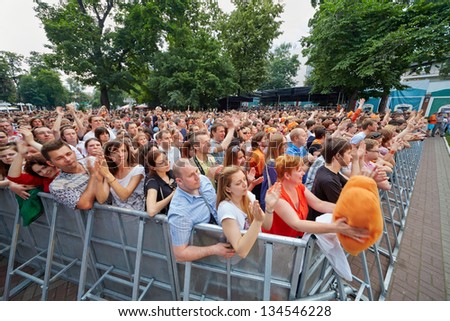 MOSCOW - JUN 23: People applaud at concert of Chaif rock-band at outdoor performance stage during VII traditional festival of live sound Music of Summer in Hermitage Garden, Jun 23 2012, Moscow Russia