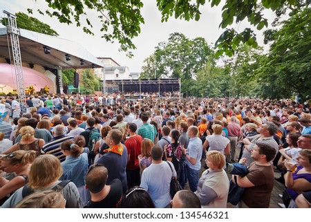 MOSCOW - JUN 23: People at concert of Chaif rock-band at outdoor performance stage during VII traditional festival of live sound Music of Summer in Hermitage Garden, Jun 23, 2012, Moscow, Russia.
