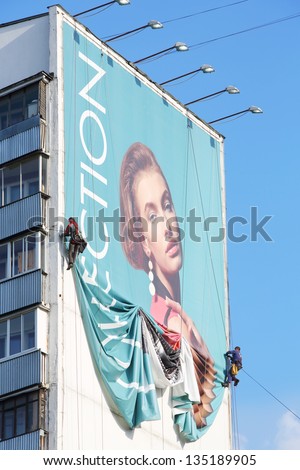 MOSCOW - MAY 16: Workers remove billboard from house, on May 16, 2012 in Moscow, Russia. Moscow does not stop work on dismantling illegally installed outdoor advertising.