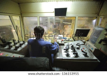 Rolling mill control cabin inside with worker.