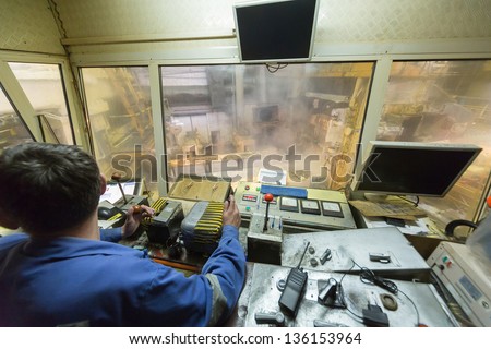 Rolling mill control cabin inside with worker.