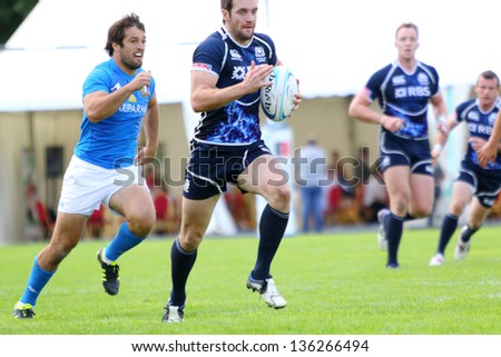 MOSCOW - JUN 30: Athlete runs with ball at second stage of European championship on rugby-7 in sports complex Luzhniki, Jun 30, 2012 Moscow, Russia. Athletes from Italy in blue, from Scotland in black
