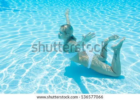 Underwater girl with closed eyes and a tattoo on his leg