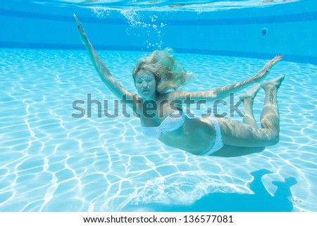 Underwater beautiful girl with closed eyes and a tattoo on his leg