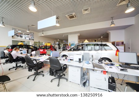 Large Office Of Shop Selling Cars. Office Workers Sit At Computers.