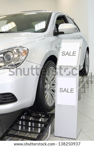 New white shining beautiful car stands on special stand in car shop.