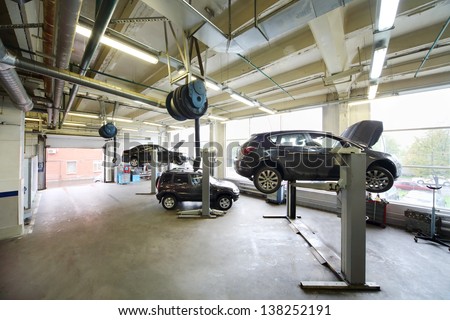 Cars on lifts in small service station. Cars prepared to diagnosis and repair.