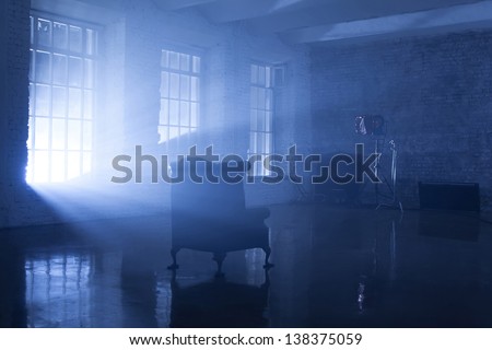 A seat in a blue backlight in studio with three windows, filmed in a rented public studio.
