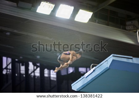 MOSCOW - APR 13: Female athlete jumps from diving-tower in Pool of SC Olympic on day of third phase of World Series of FINA Diving, April 13, 2012, Moscow, Russia.