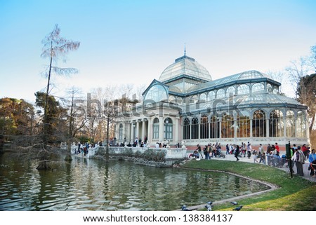 MADRID - MARCH 11: Tourists walk near pond and Glass Pavilion in Retiro Park, on March 11 2012 in Madrid, Spain. In 2012 number of tourists in resorts of Spain increased 1.5 times compared to 2011.