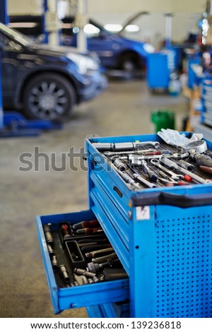 Blue metal tool cabinet with open case at service station, shallow dof