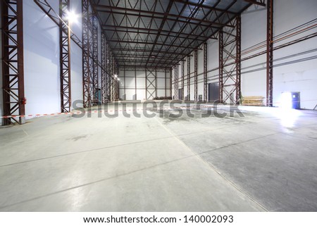 Large Light Empty Hangar With Concrete Floor And Entrances For Large Trucks.