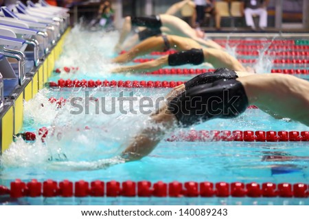 Group swimmers dive back into the water in the pool