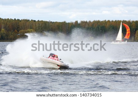 Man fast floats at power boat on river at competitions at autumn day.