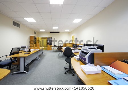Empty working areas with armchairs and tables in light modern office.