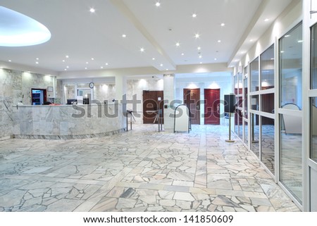 Reception area, glass entrance doors in office building at evening.