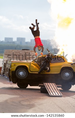 MOSCOW - AUG 25: Stuntman flies over the burning car on Festival of art and film stunt Prometheus in Tushino on August 25, 2012 in Moscow, Russia. The festival was organized in 1998.