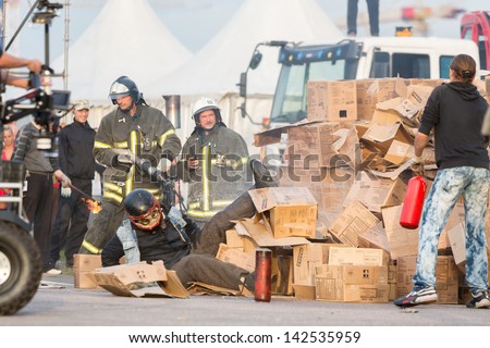MOSCOW - AUG 25: Rescue workers help person after jumping from height into burning box on Festival of art, film stunt Prometheus in Tushino, Aug 25 2012, Moscow Russia. Festival was organized in 1998.