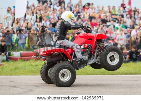 MOSCOW - AUG 25: Kid rides on the rear wheels on a quad bike on Festival of art and film stunt Prometheus in Tushino on August 25, 2012 in Moscow, Russia. The festival was organized in 1998.