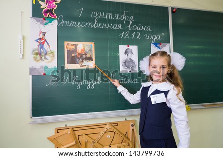MOSCOW - SEP 1: Little school girl Anya 7 years old stands at the blackboard with a pointer in School No. 1349 on the first day of school on September 1, 2012 in Moscow, Russia.
