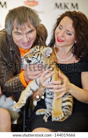 MOSCOW - OCT 22: Circus actress, animal trainer Karina Bagdasarova with tiger cub and soviet and russian musician and producer Bari Alibasov at Phoney New Year celebration, Oct 22 2012, Moscow Russia.