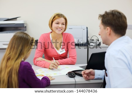 Little girl and her father sit in office and talk with realtor. Focus on woman.