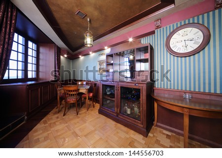 Bar in wooden closet and table in english cigar room for rest.