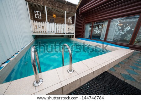 MOSCOW - JAN 1: The pool in the courtyard of log house in Elite Complex Manor Bath at Elk Island on January 1, 2013 in Moscow, Russia.
