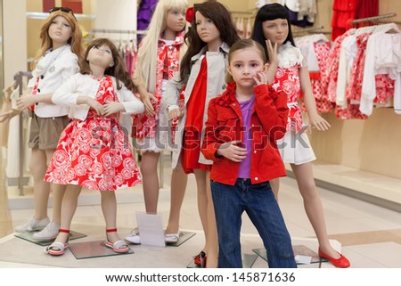 MOSCOW - MAR 18: Jeanette 6 years old trying on clothes together with mannequins in the store children clothes Jakimanka on March 18, 2012 in Moscow, Russia.