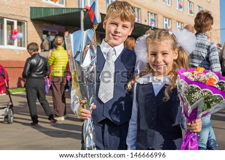 Sister and brother with the flowers on the first day of school