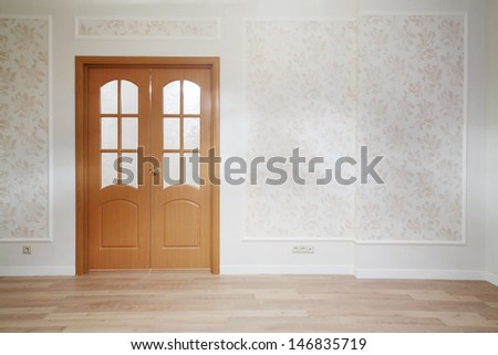 Wooden door in simple room with wooden floor in new apartment.