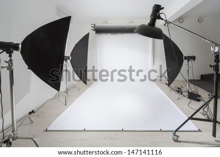 Photographic Equipment And A White Backdrop In Studio.