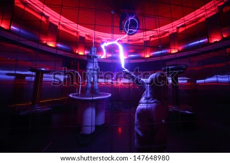 MOSCOW - FEBRUARY 8: Two men in special clothes hold lightning at presentation of attraction Megavolt - master of lightning at VVC, on February 8, 2013 in Moscow, Russia.