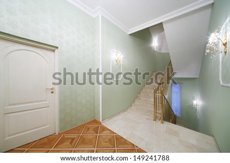 Flight of stairs, white marble stairs, green wallpaper in house in classical style.