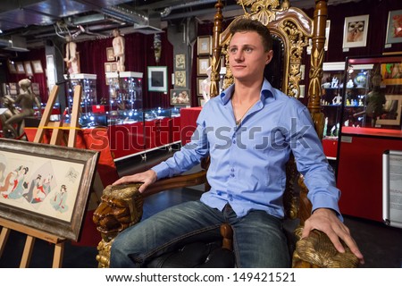 MOSCOW - JAN 24: A man sits on a wooden throne in Museum-Shop Point G on Novy Arbat on January 24, 2013 in Moscow, Russia.