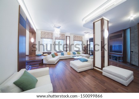 The Spacious, Well Lit Living Room With A Round Glass Table, Chairs And Sofa