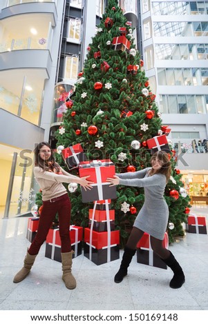 MOSCOW - DEC 20: Two employees of the bank with a gift in hands standing next to a large Christmas tree in the Main office Rosbank on December 20, 2012 in Moscow, Russia.