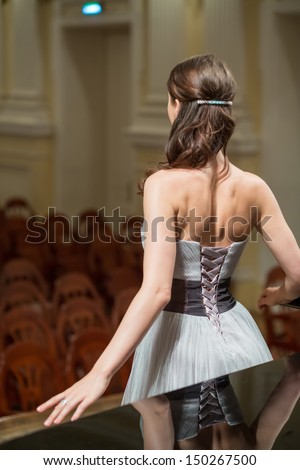 Beautiful opera singer is back in the concert hall, focus on the girls back.