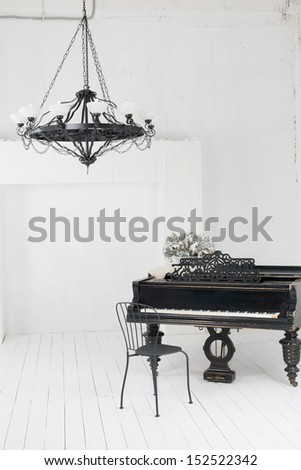 A Beautiful Chandelier And A Piano In The Room With White Floors And Walls
