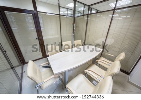 Small meeting room blinds closed with a table and leather chairs