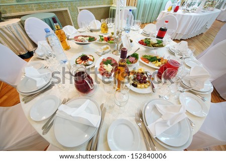 Table with dishes, a variety of drinks and snacks from the meat, vegetables and fruit.