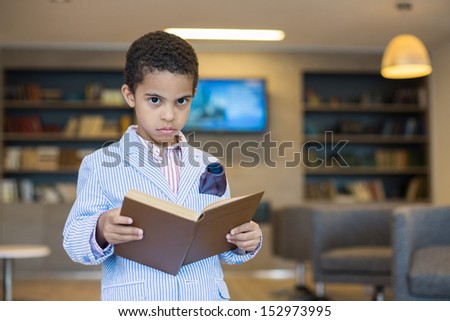 Mulatto boy in a striped jacket with a book in hand
