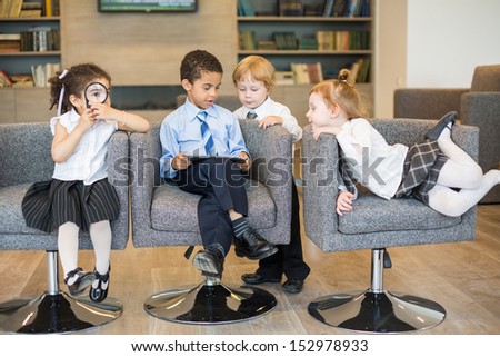 Four children in suits having fun in a business center