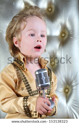Portrait of a little boy in pop retro suit sings a song