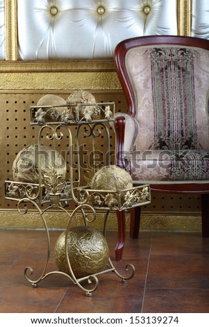 Metal stand with golden balls near chair in the interior of the studio