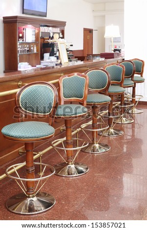 Beautiful green classic chairs stand next to bar counter in empty room.