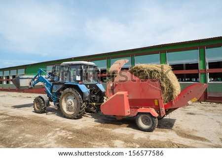 Tractor with hay in a trailer on the farm