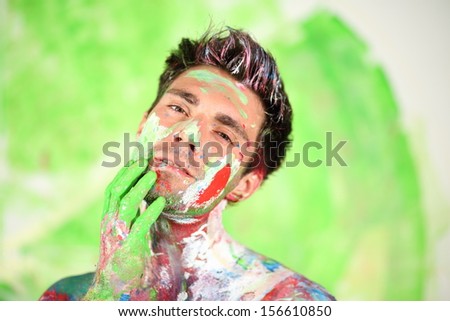 Whole painted young man with hand near face bowed his head