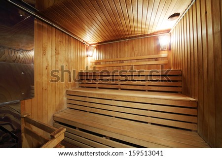 Healthy wooden steam sauna with with two lamps and wood seating